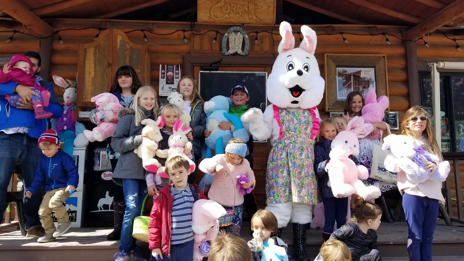 Children and a person in an Easter bunny costume gather outside the entrance to the Corral Bar and Steakhouse in Big Sky, Montana.